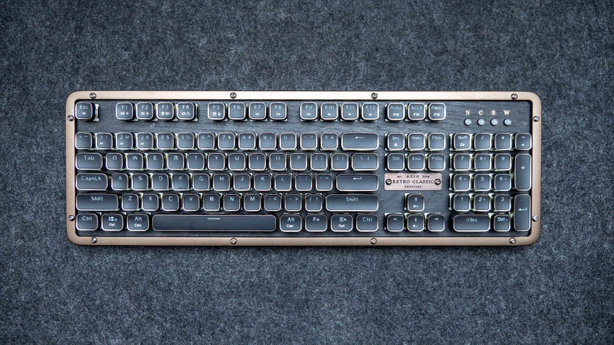 The Azio Retro Classic Prestige full-size mechanical keyboard on a wood desk.