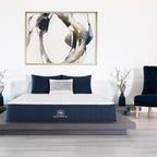 Signature mattress from Brooklyn Bedding next to a blue armchair
