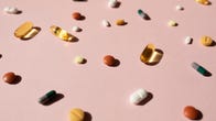 Various pills on light pink background