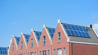 Brick row houses with solar panels on each roof.