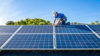 A solar panel installer works on solar panels.