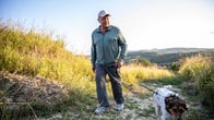 Senior man hiking with dog in nature