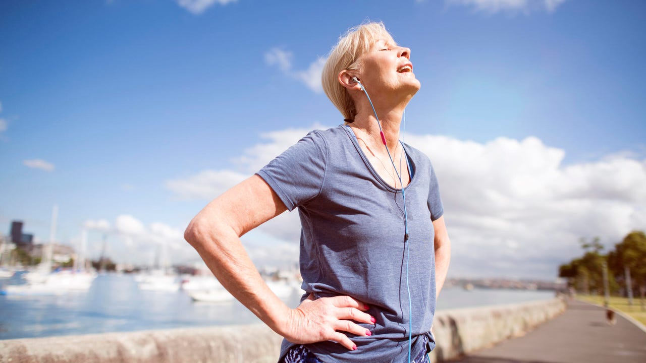 Woman in workout clothes with earbuds in outside