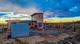 A stucco house in the desert at sunset.