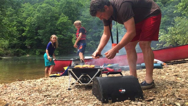 man tending charcoal grill